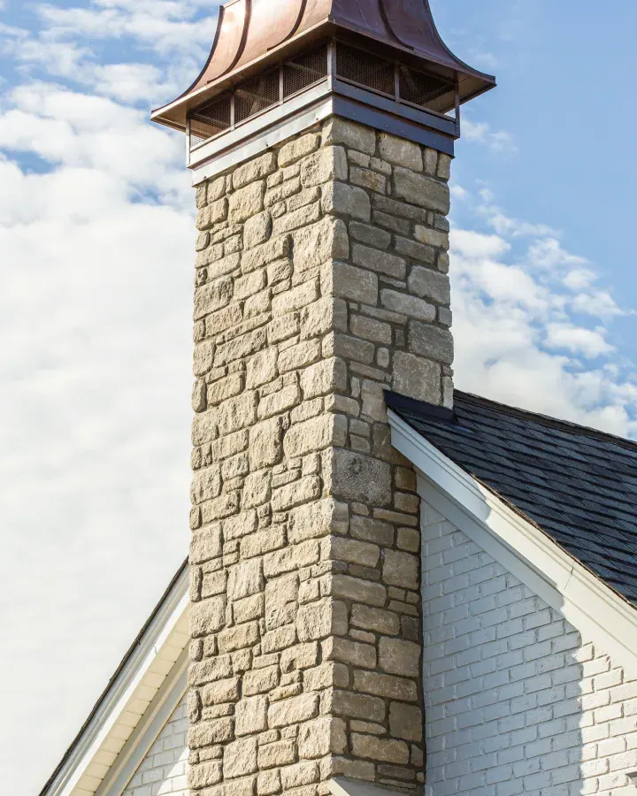 Copper-capped stone chimney on a RALLE Homes project